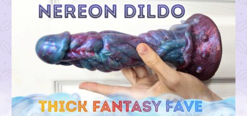 Fabled Toys Nereon fantasy dildo held in hand over white door