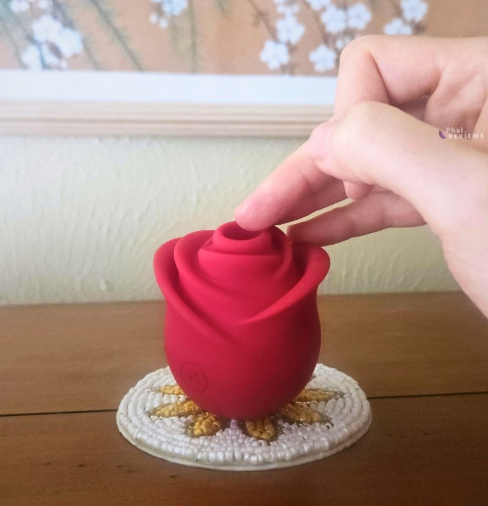 Focus on Zen Rose vibrator's air pulsing suction opening vs. finger