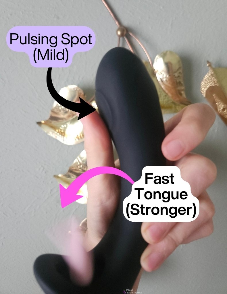 Closeup of the G-spot pulsing / tapping point above the moving pink tongue in the Glossa vibrator, held in hand in front of brass golden leaf ornament
