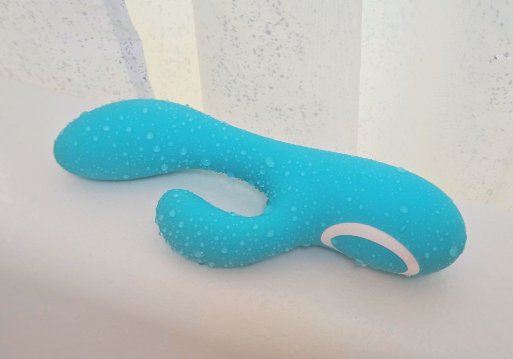 Rumble Rabbit vibrator's turquoise silicone covered in water droplets on bath to show water resistance