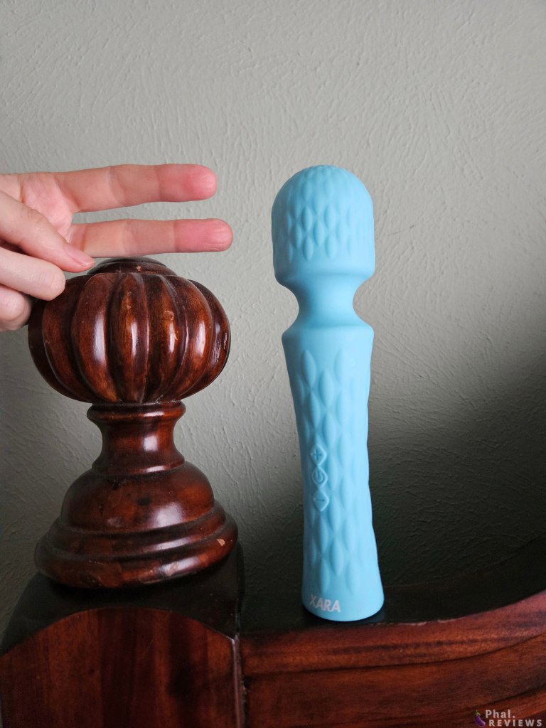 Speed ​​​​​​Wand standing next to bedpost and 2 fingers, showing total length and head size