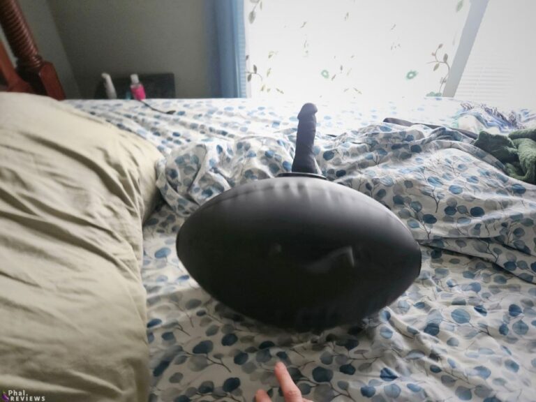 Inflatable dildo mount tips over onto bed without body weight on top.